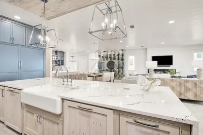 a large kitchen with two sinks and a living room at Sunset Serenity in Panama City Beach