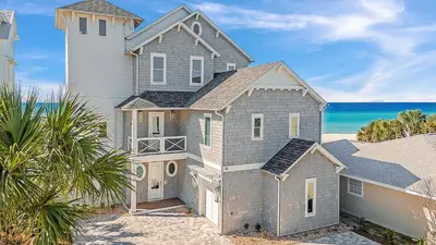 a house on the beach with the ocean in the background at Sunset Serenity in Panama City Beach