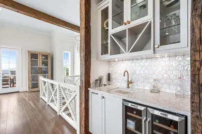 a kitchen with white cabinets and a staircase at Stars on the Water in Santa Rosa Beach