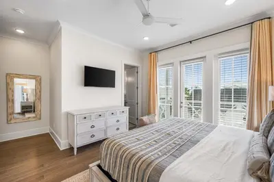 a bedroom with a bed and a tv on the wall at Stars on the Water in Santa Rosa Beach
