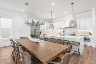 a kitchen with a wooden table and chairs at 30A Sunset 6 Bedroom in Santa Rosa Beach