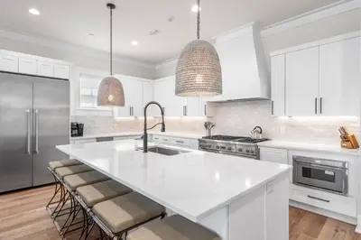a kitchen with white cabinets and a large white island at 30A Sunset 6 Bedroom in Santa Rosa Beach