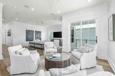 a white living room with white chairs and a table at 30A Sunset 6 Bedroom in Santa Rosa Beach