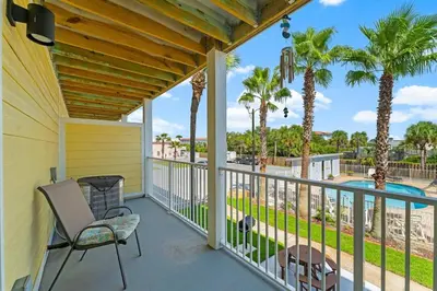 a balcony with a view of a pool and palm trees at Sand Castles West B28 (1/1) in Panama City Beach