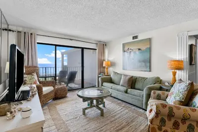 a living room with a couch and a tv at Moondrifter #803 in Panama City Beach