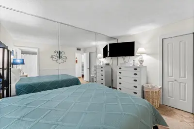 a bedroom with two beds and a large mirror at Moondrifter #803 in Panama City Beach