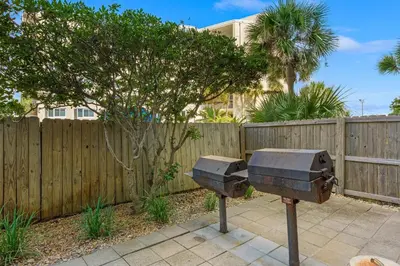 a statue of two trash cans in front of a fence at Moondrifter #803 in Panama City Beach