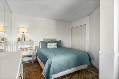 a bedroom with a bed with a green blanket at Moondrifter #803 in Panama City Beach