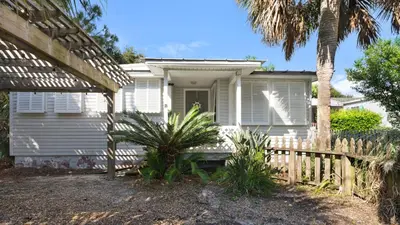 a white house with a fence and palm trees at Vintage Waves in Laguna Beach