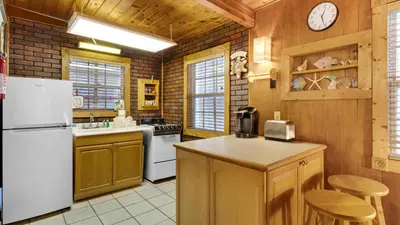 a kitchen with wooden walls and a white refrigerator at Vintage Waves in Laguna Beach