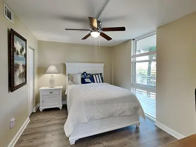 a bedroom with a bed and a ceiling fan at Dunes of Panama #B203 in Panama City Beach