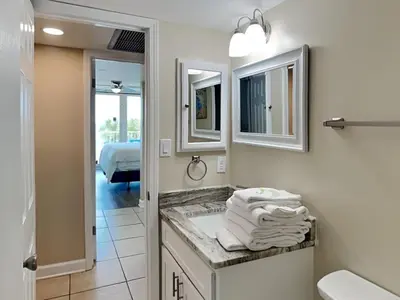 a bathroom with a sink and two mirrors at Dunes of Panama #B203 in Panama City Beach