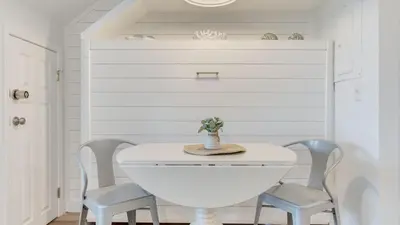 a white table and two chairs in a room at Ocean View Balcony Heated Pool Steps to the Beach The Sea Chord by AvantStay in Santa Rosa Beach