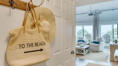 a to the beach bag hanging on a door in a living room at Ocean View Balcony Heated Pool Steps to the Beach The Sea Chord by AvantStay in Santa Rosa Beach