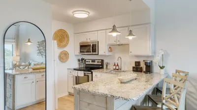 a kitchen with white cabinets and a marble counter top at Ocean View Balcony Heated Pool Steps to the Beach The Sea Chord by AvantStay in Santa Rosa Beach