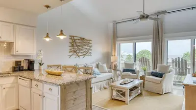 a kitchen and living room with a large window at Ocean View Balcony Heated Pool Steps to the Beach The Sea Chord by AvantStay in Santa Rosa Beach