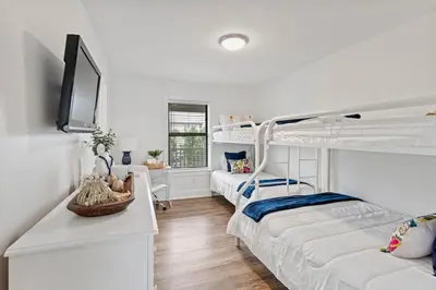 a room with two bunk beds and a couch at Beach Condo with Heated POOL and Tennis Courts and Beach Access and 6 Beds that Sleep 8 in Santa Rosa Beach