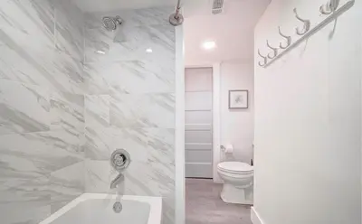 a white bathroom with a toilet and a tub at Sunbird Resort! Stunning Remodeled Beachfront Condo! Free Beach Chair Service! by Dolce Vita PCB! in Panama City Beach