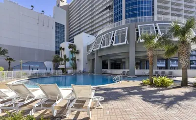 a swimming pool with lounge chairs and a building at Spectacular Ocean View Condo! Steps to the Beach! by Dolce Vita Getaways PCB! in Panama City Beach