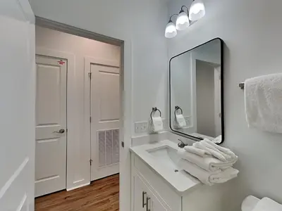 a white bathroom with a sink and a mirror at Sunset On Snapper A in Panama City Beach