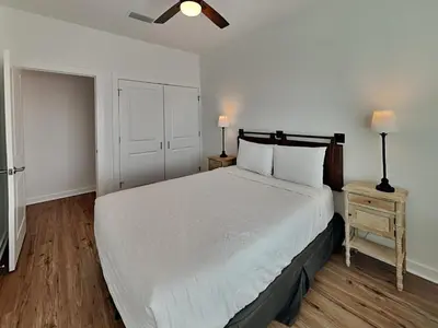 a bedroom with a large white bed and a night stand at Sunset On Snapper A in Panama City Beach
