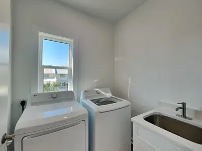 a white laundry room with a sink and a washing machine at Sunset On Snapper A in Panama City Beach