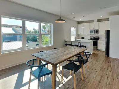 a kitchen and dining room with a wooden table and chairs at Sunset On Snapper A in Panama City Beach