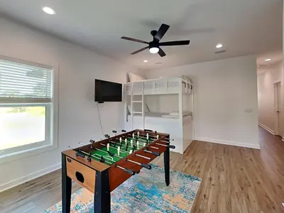 a living room with a foosball table in the middle at Sunset On Snapper B in Panama City Beach
