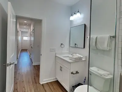 a white bathroom with a sink and a mirror at Sunset On Snapper B in Panama City Beach