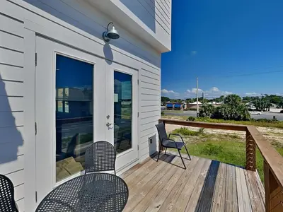a porch with chairs and tables on a house at Sunset On Snapper B in Panama City Beach