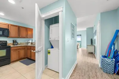 a kitchen with a washer and dryer in it at Origin 1227 Beachy Dreams in Panama City Beach