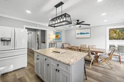 a kitchen and dining room with a white refrigerator at Beach House - Barefoot House by Panhandle Getaways in Panama City Beach