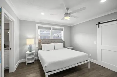 a bedroom with a bed and a ceiling fan at Beach House - Barefoot House by Panhandle Getaways in Panama City Beach