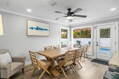 a dining room with a table and chairs and a ceiling fan at Beach House - Barefoot House by Panhandle Getaways in Panama City Beach
