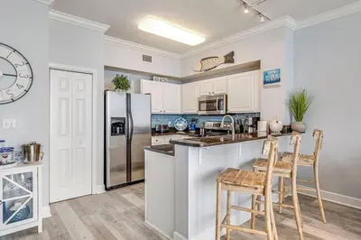 a kitchen with a refrigerator and a table and chairs at Stunning Beachfront 