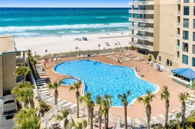 a large swimming pool next to a beach and a building at Stunning Beachfront 