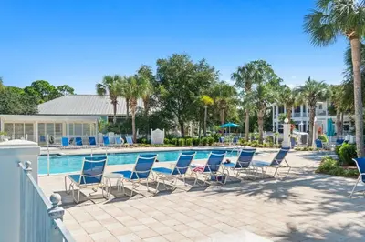 a group of chairs sitting next to a swimming pool at Carillon Beach House - Grits Carlton by Panhandle Getaways in Panama City Beach
