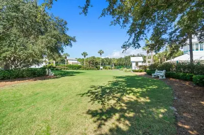 a park with a bench in the middle of a yard at Carillon Beach House - Grits Carlton by Panhandle Getaways in Panama City Beach