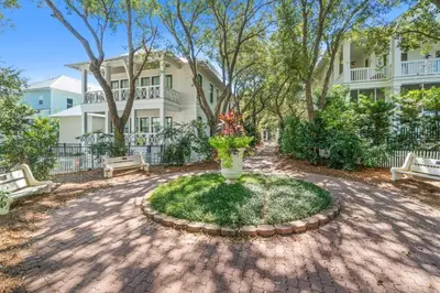 a vase with flowers in a circle in front of a house at Carillon Beach House - Grits Carlton by Panhandle Getaways in Panama City Beach