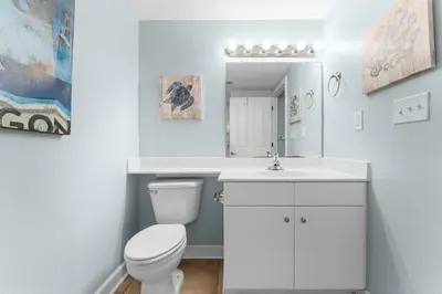 a white bathroom with a toilet and a sink at Shores Of Panama #0526 in Panama City Beach
