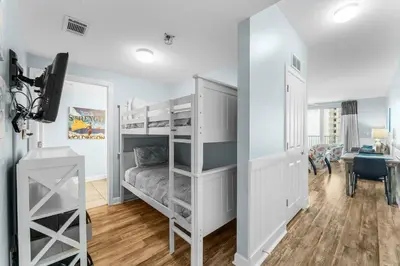 a bedroom with a bunk bed and a desk at Shores Of Panama #0526 in Panama City Beach