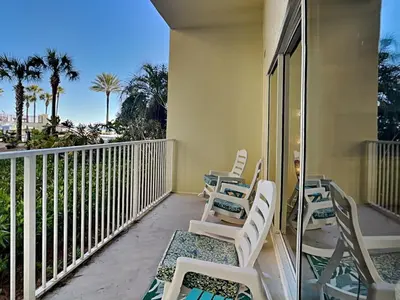 a row of chairs on a balcony with palm trees at Shores of Panama #109 in Panama City Beach
