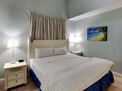 a bedroom with a white bed and two night stands at Shores of Panama #109 in Panama City Beach