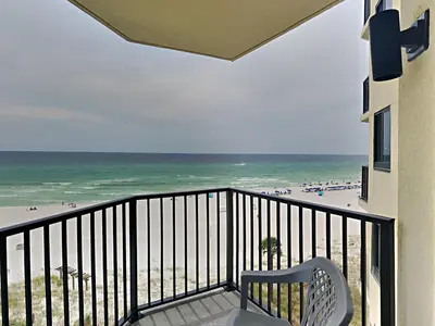a balcony with a chair and the beach at Sunbird Beach Resort #604 East in Panama City Beach