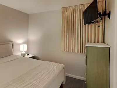 a bedroom with a bed and a flat screen tv at Sunbird Beach Resort #604 East in Panama City Beach