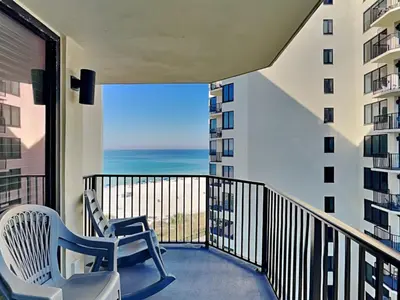 a balcony with two chairs and a view of the ocean at Sunbird Beach Resort #712 East in Panama City Beach
