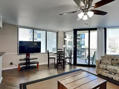 a living room with a couch and a tv and a table at Sunbird Beach Resort #712 East in Panama City Beach