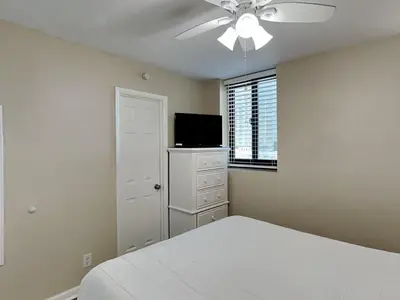 a white bedroom with a bed and a ceiling fan at Sunbird Beach Resort #712 East in Panama City Beach