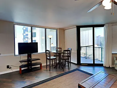 a living room with a television and a table with chairs at Sunbird Beach Resort #712 East in Panama City Beach