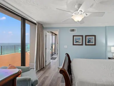 a bedroom with a bed and a balcony at Edgewater Tower III #1212 in Panama City Beach